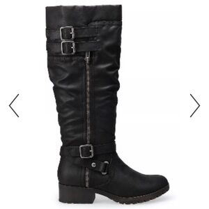 Tall black boots with zipper and buckle detail